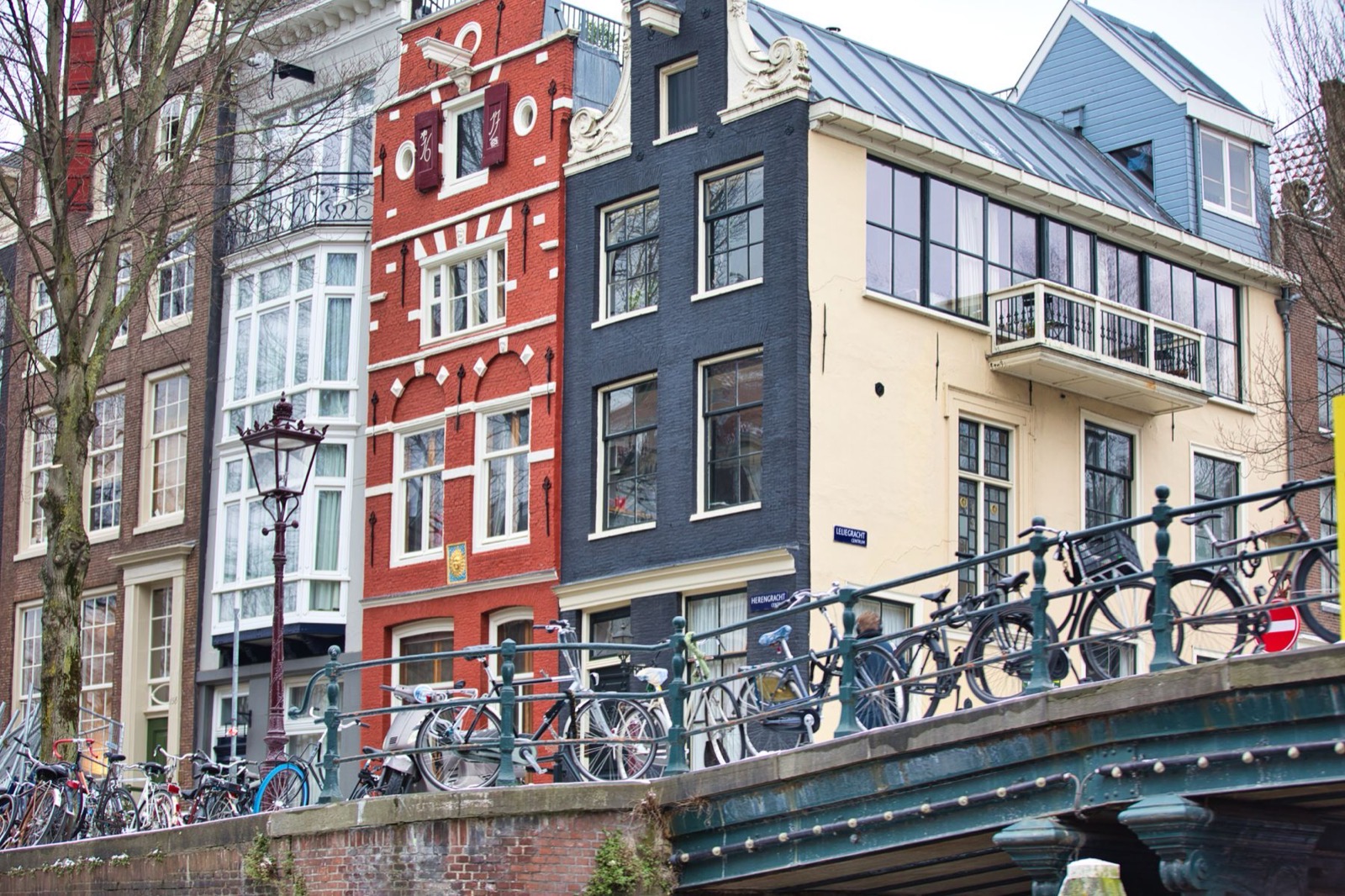 Kleurige Amsterdamse gevels met fietsen op een brug