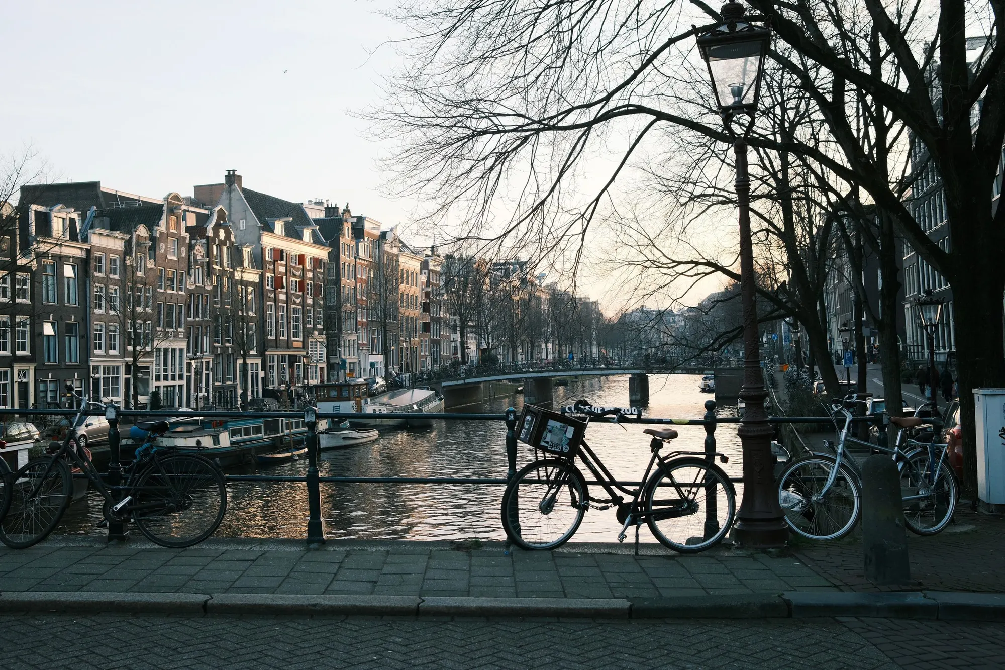 Amsterdamse gracht met fietsen in het avondlicht