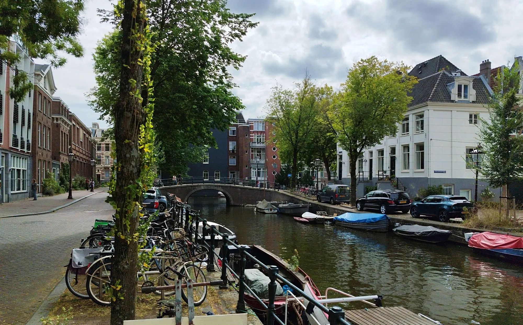 Gracht in Amsterdam met fietsen en afgedekte boten